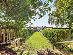 A well-maintained garden pathway leading to a house with a visible front yard and a wooden fence on one side. - 2 Bed in Kelsall (oc-94445) (Kelsall)