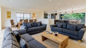A spacious living area with two sofas, a coffee table, and a dining area with chairs and a table. - 3 Bed in Belford (oc-78058) (Easington)