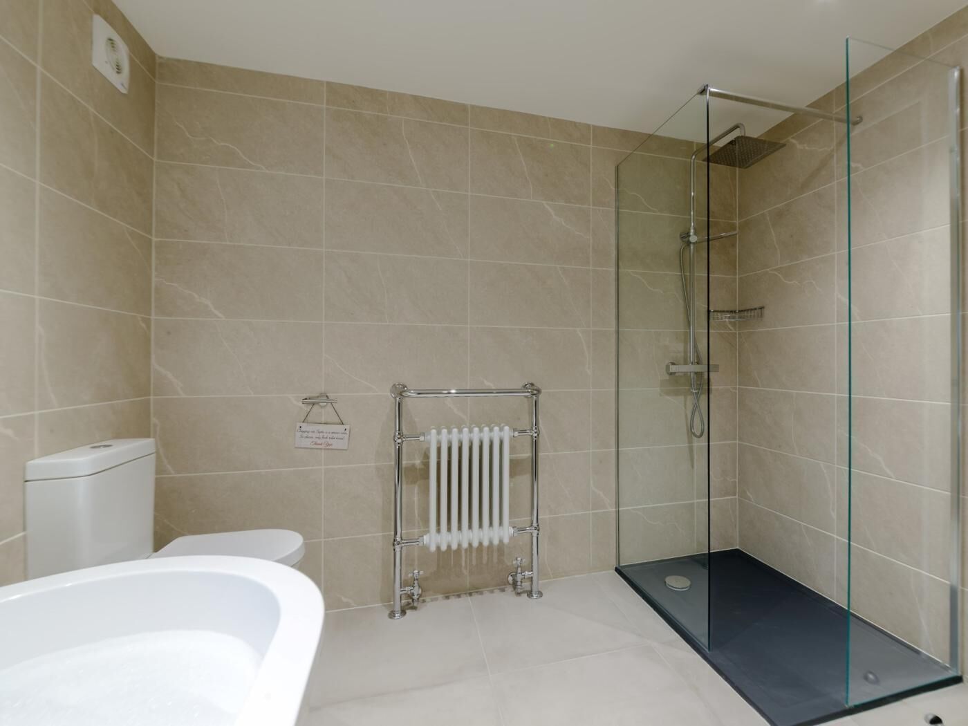 Une salle de bain moderne avec une douche à parois de verre, une baignoire blanche et des toilettes.