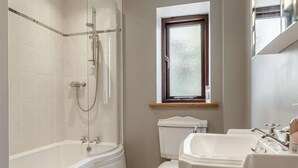 Ein Badezimmer mit einer Badewanne, Toilette und Waschbecken.