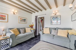 A living room with two grey sofas, a small table with a lamp, and artwork on the walls. - 2 Bed in Aberdyfi (oc-dy020) (Aberdovey)