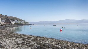 A calm lake with boats, a red buoy, and houses along the shore. - 2 Bed in Aberdyfi (oc-dy020) (Aberdovey)
