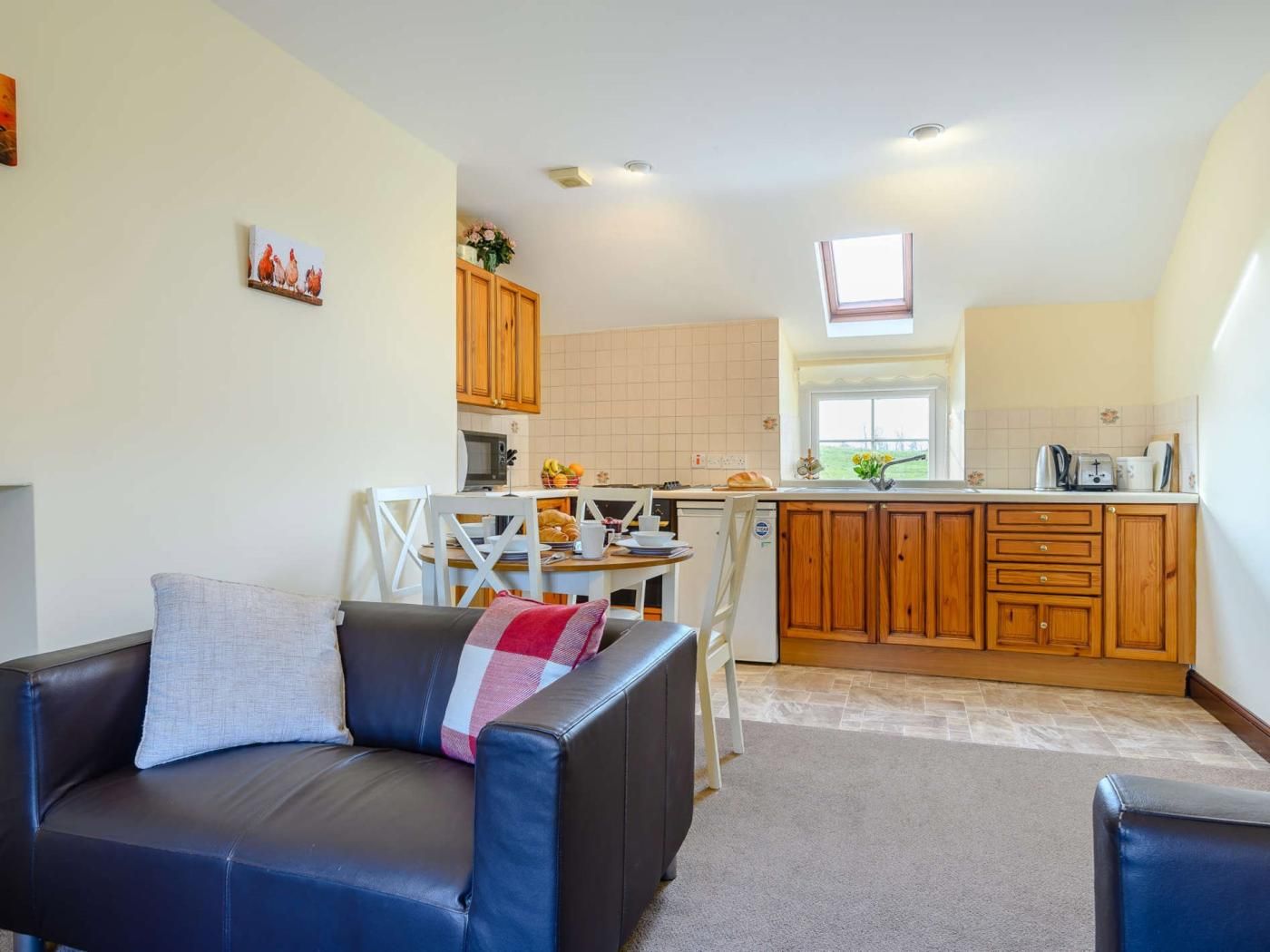 A compact living space with a sofa, a dining table, and a kitchenette.