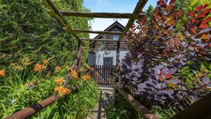 A wooden pergola with a view of a rustic building through a wooden fence. - 1 Bed in Paignton (oc-55119) (Paignton)