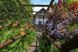 A wooden pergola with a view of a rustic building through a wooden fence. - 1 Bed in Paignton (oc-55119) (Paignton)