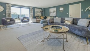 Un salon moderne avec un canapé, des fauteuils et une table basse.