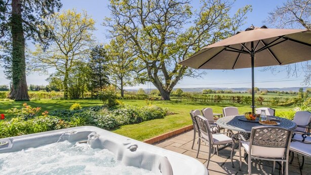 Un jacuzzi, asientos al aire libre y vistas a un viñedo.