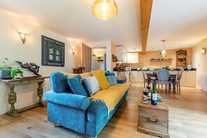 Ein Wohnzimmer mit Sofa, Couchtisch und Essbereich mit Stühlen und Tisch.