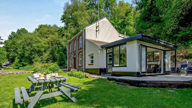 Ein modernes Haus mit Terrasse und Essplatz.