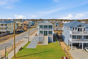 A coastal residential area with houses featuring balconies and a prominent building with a staircase. - Shoreview Manor | 35 ft to the beach | Private Pool and Hot Tub (Kitty Hawk)