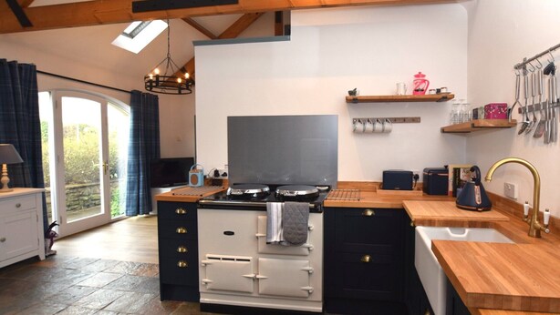 A kitchen with a stove, a sink, and a window. - 1 Bed in Craster (94372) (Longhoughton)
