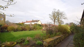 A garden with a stone wall, a lawn, and a pathway. - 1 Bed in Craster (94372) (Longhoughton)