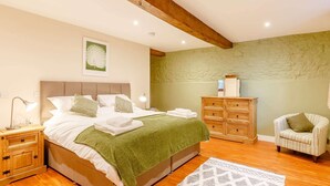A bedroom with a bed, wooden nightstands, a dresser, a chair, and a patterned rug. - 2 Bed in Umberleigh  (88605) (Chittlehampton)