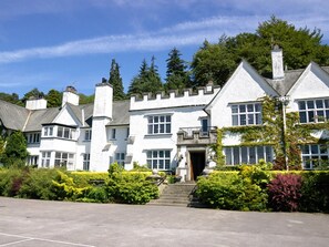 A large, white, multi-story building with a symmetrical facade, a central entrance, and a statue in front. - 2 Bed in Hawkshead (oc-llh12) (Claife)