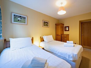 A hotel room with two beds, a wardrobe, and a door. - 2 Bed in Hawkshead (oc-llh12) (Claife)