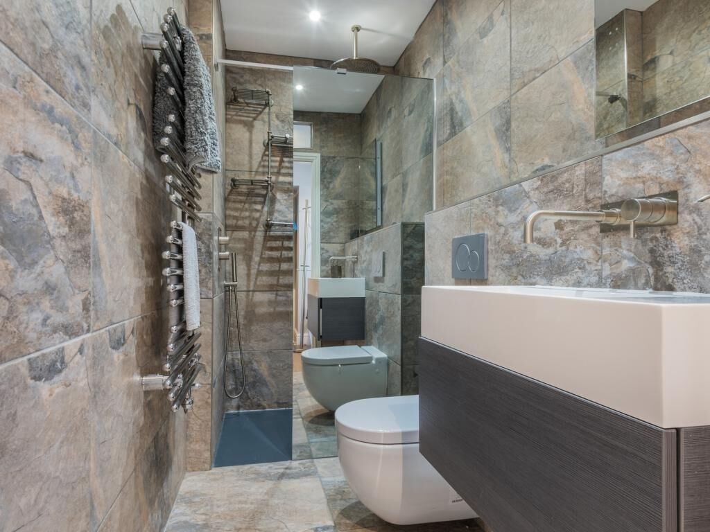 Une salle de bain moderne équipée d’une baignoire, de toilettes et d’un espace douche.