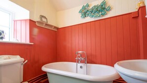 Une salle de bain avec une baignoire sur pieds, des toilettes et un lavabo.