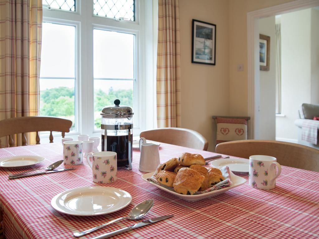 Une table à manger dressée avec des assiettes, des couverts et une assiette de pâtisseries.