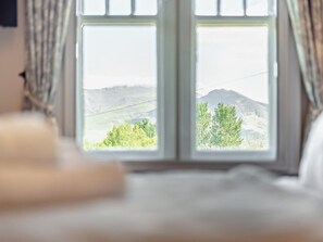 Ein Zimmer mit einem großen Fenster und Blick auf eine Berglandschaft.