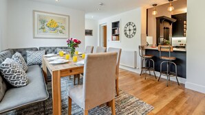 A modern living room with a sofa, dining table, and kitchen area. - 4 Bed in Cockermouth (oc-91210) (Wythop)
