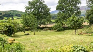 A rural landscape with rolling hills, trees, and a stone wall. - 2 Bed in Keswick (oc-sz330) (Saint John's Castlerigg and Wythburn)