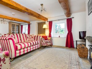 A living room with a striped sofa, a patterned armchair, a fireplace, and a television. - 2 Bed in Keswick (oc-sz330) (Saint John's Castlerigg and Wythburn)