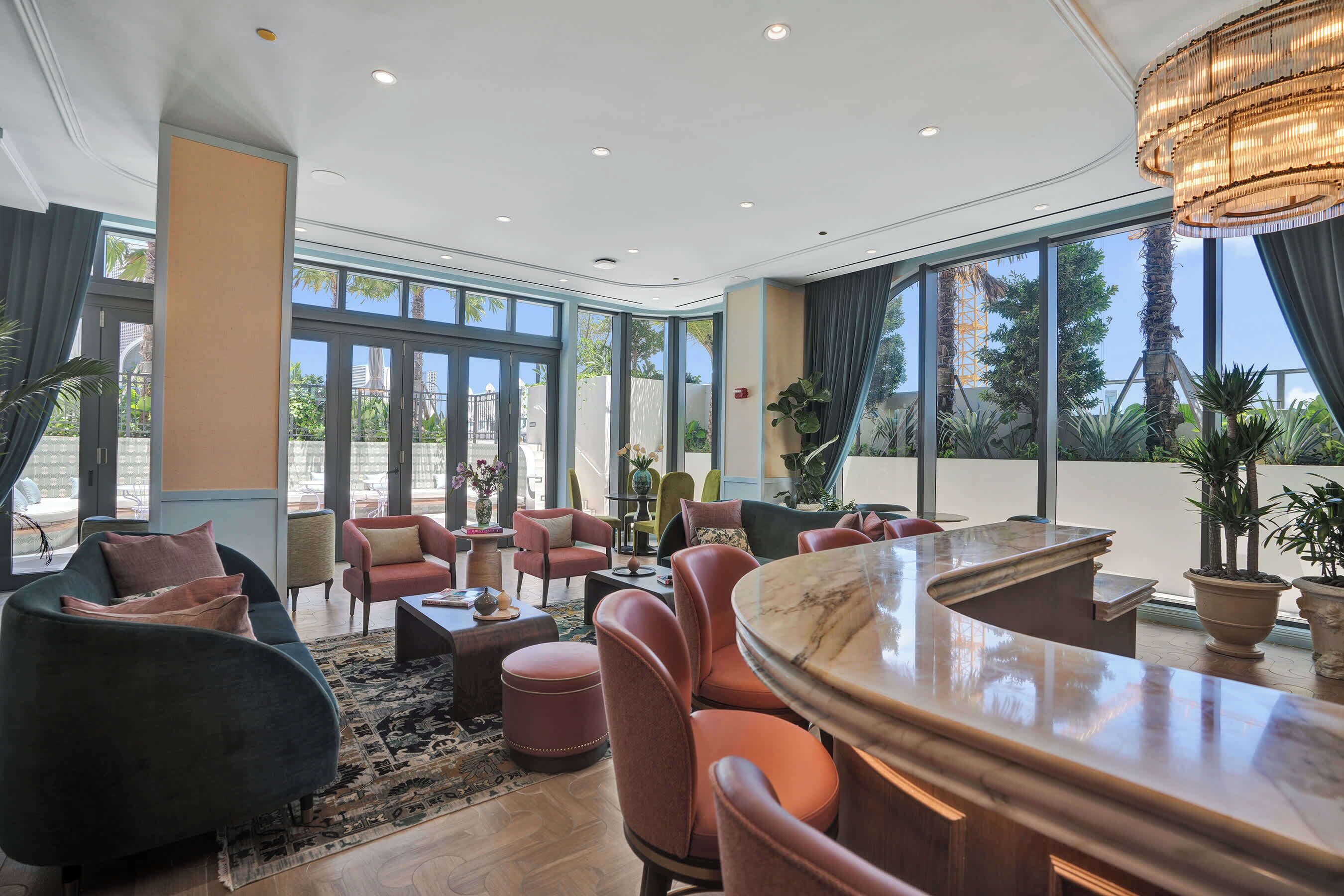 Un intérieur moderne avec un bar, des espaces pour s’asseoir et de grandes fenêtres.