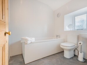A modern bathroom with a bathtub, toilet, and a window. - 2 Bed in Eden Valley (SZ455) (Warcop)