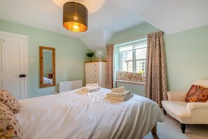 A bedroom with a bed, a dresser, a window with curtains, a chair, and a hanging light fixture. - 3 Bed in Keswick (oc-sz542) (Keswick)