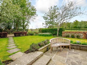 A garden with a stone pathway leading to a wooden bench. - 2 Bed in Hindringham (KT102) (Hindringham)