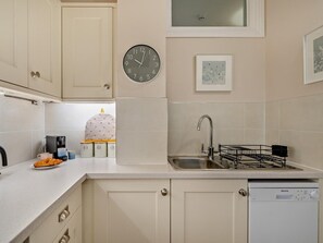 A kitchen with a clock, a coffee maker, a sink, and a dishwasher. - 3 Bed in Ambleside (oc-82119) (Claife)