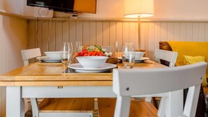 A dining table with plates, glasses, and a bowl of vegetables. - 3 Bed in Cleator (oc-88627) (Ennerdale and Kinniside)