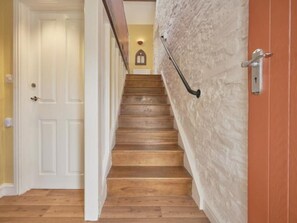 A wooden staircase with a handrail, a white door at the top, and a textured wall. - 1 Bed in Cockermouth (oc-sz358) (Dean)