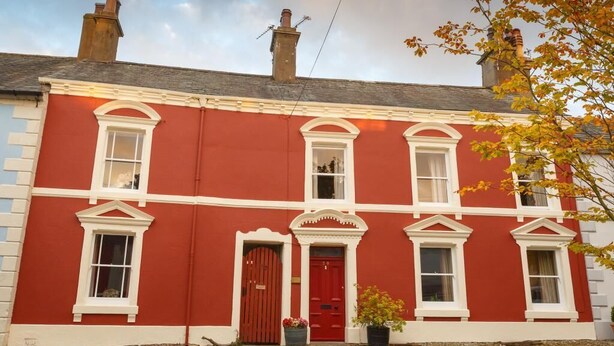 A red building with white trim, a red door, and a chimney. - 3 Bed in Cockermouth (SZ022) (Cockermouth)