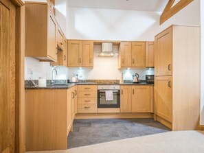 A kitchen with wooden cabinets, a countertop, a stove, and a sink. - 2 Bed in Newlands Valley (SZ352) (Borrowdale)