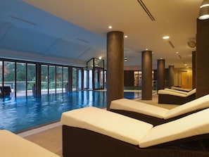 A swimming pool area with lounge chairs, large windows, and a modern interior design. - 2 Bed in Newlands Valley (SZ351) (Borrowdale)