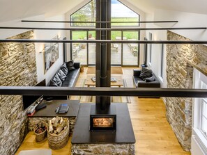 Ein modernes Interieur mit einer Steinwand, einem Kamin und einer Sitzecke mit Sofas.