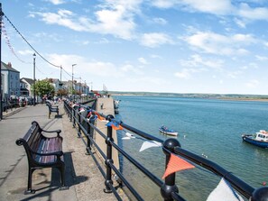 A waterfront promenade with benches, a railing, and boats on the water. - 2 Bed in Beaworthy (oc-hembu) (Sheepwash)