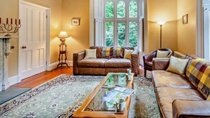 Ein gemütliches Wohnzimmer mit Kamin, einem großen Fenster und einer bequemen Sitzecke.