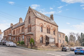 A large brick building with multiple windows and a prominent entrance. - 1 Bed in Penrith (oc-sz003) (Penrith)