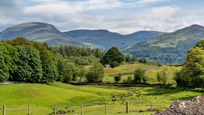 A rural landscape with rolling hills, a small house, and a fence. - 1 Bed in Outgate and Tarn Hows (78403) (Outgate)
