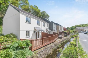 A row of modern, two-story houses with a narrow waterway between them. - 3 Bed in Falmouth (oc-42709) (Goldenbank)