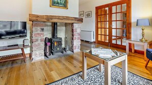 A living room with a fireplace, a television, and a table with board games. - 2 Bed in Appleby-in-westmorland (oc-91029) (Dufton)