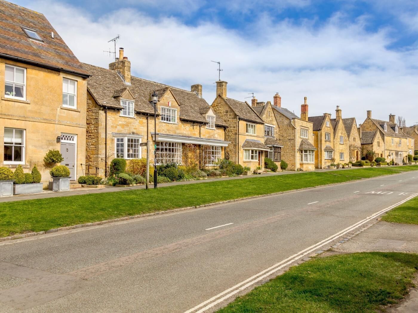 A row of stone houses with a clear road in front.