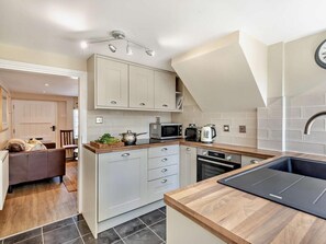 A modern kitchen with a built-in oven, microwave, and kettle, a wooden countertop, and a sink. - 1 Bed in Broadway (oc-broad) (Broadway)