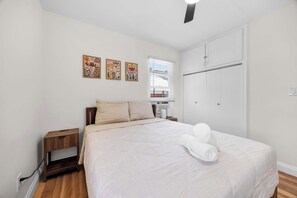A bedroom with a bed, bedside tables, a wardrobe, and artwork on the wall. - Old Town Middle Unit w/ Foosball & BBQ Grill (San Diego)