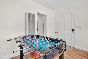 A foosball table in a room with white walls and a wooden floor. - Old Town Middle Unit w/ Foosball & BBQ Grill (San Diego)