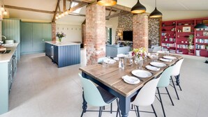 Un coin repas avec une table en bois dressée pour six personnes, entourée de chaises bleu clair.