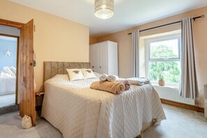 A bedroom with a large bed, a wardrobe, a window with curtains, and a star decoration on the wall. - 3 Bed in Lydbrook (oc-94490) (Central Lydbrook)