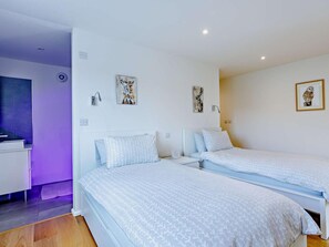 Ein Hotelzimmer mit zwei Betten, einem Schreibtisch und Bildern an den Wänden.